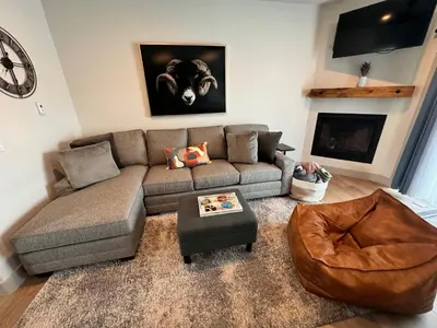 a living room with a couch and a table at Modern Granby Wonder by Leavetown Vacations in Granby