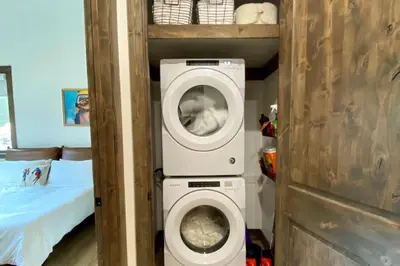 a washing machine in a small room with a bed at Seasons 1889 - Keystone in Keystone