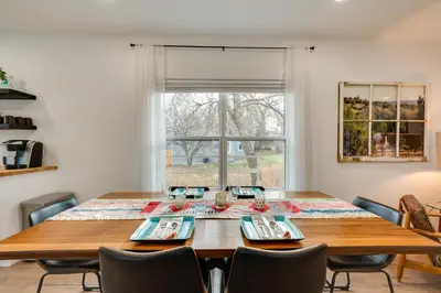 a dining room table with chairs and a large window at Chic Erie Vacation Rental about 14 Mi to Boulder! in Erie