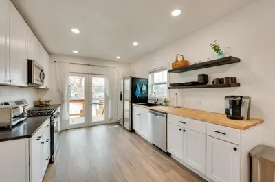 a kitchen with white cabinets and a wooden counter top at Chic Erie Vacation Rental about 14 Mi to Boulder! in Erie