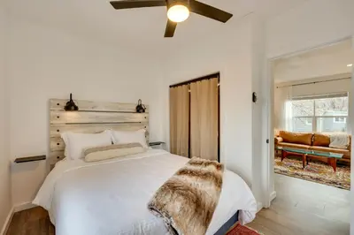 a bedroom with a white bed and a couch at Chic Erie Vacation Rental about 14 Mi to Boulder! in Erie