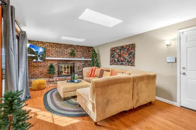 a living room with a couch and a fireplace at ᨒFIREHAUSᨒHotTubᨒCinemaᨒBBQᨒBadmintonᨒGames in Arvada