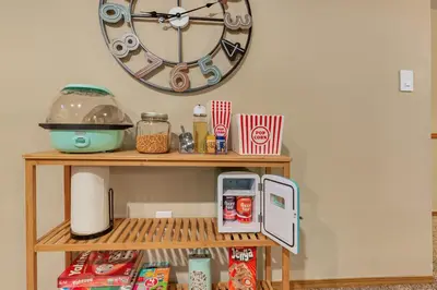 a clock on the wall above a shelf with food at ᨒFIREHAUSᨒHotTubᨒCinemaᨒBBQᨒBadmintonᨒGames in Arvada