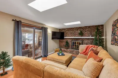 a living room with a couch and a fireplace at ᨒFIREHAUSᨒHotTubᨒCinemaᨒBBQᨒBadmintonᨒGames in Arvada