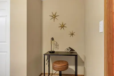 a table with a stool and stars on the wall at ᨒFIREHAUSᨒHotTubᨒCinemaᨒBBQᨒBadmintonᨒGames in Arvada