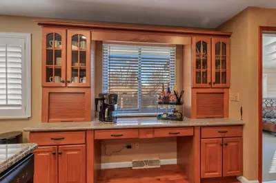 a kitchen with wooden cabinets and a window at ᨒFIREHAUSᨒHotTubᨒCinemaᨒBBQᨒBadmintonᨒGames in Arvada