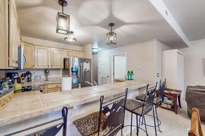 a large kitchen with a counter and chairs in it at Mountain Vista in Fraser