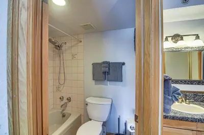 a bathroom with a white toilet and a sink at Ski-InandSki-Out Winter Park Condo with Mountain Views in Winter Park