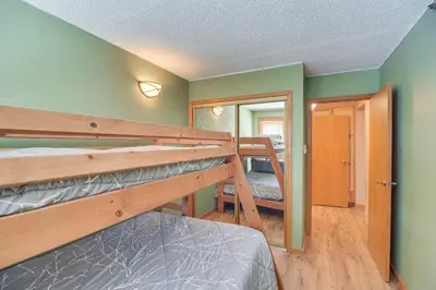 a bedroom with two bunk beds and a hallway at Ski-InandSki-Out Winter Park Condo with Mountain Views in Winter Park