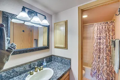 a bathroom with a sink and a mirror and a shower at Ski-InandSki-Out Winter Park Condo with Mountain Views in Winter Park