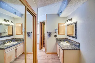 a bathroom with two sinks and two mirrors at Ski-InandSki-Out Winter Park Condo with Mountain Views in Winter Park