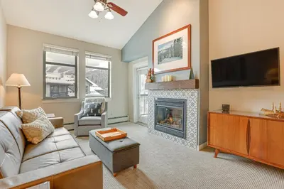a living room with a couch and a fireplace at Ski-InandSki-Out Winter Park Condo with Hot Tub Access in Winter Park