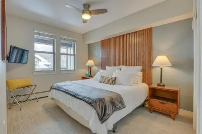 a bedroom with a large bed with a ceiling fan at Ski-InandSki-Out Winter Park Condo with Hot Tub Access in Winter Park