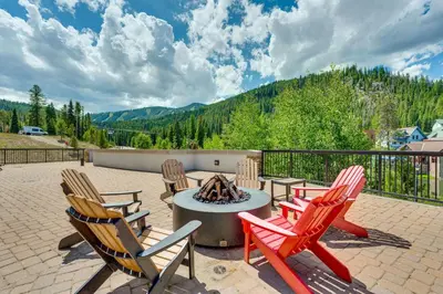 a patio with four chairs and a fire pit at Ski-InandSki-Out Winter Park Condo with Hot Tub Access in Winter Park