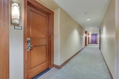 a hallway with a wooden door and a carpet at Ski-InandSki-Out Winter Park Condo with Hot Tub Access in Winter Park