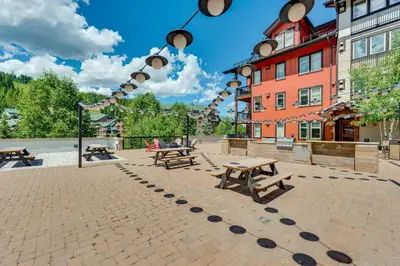 a courtyard with picnic tables and a building at Ski-InandSki-Out Winter Park Condo with Hot Tub Access in Winter Park