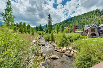 a river flows through a town with a mountain at Ski-InandSki-Out Winter Park Condo with Hot Tub Access in Winter Park