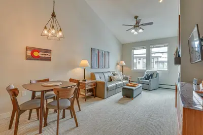 a living room with a table and a couch at Ski-InandSki-Out Winter Park Condo with Hot Tub Access in Winter Park