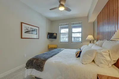 a bedroom with a large bed with a ceiling fan at Ski-InandSki-Out Winter Park Condo with Hot Tub Access in Winter Park