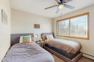 a bedroom with two beds and a window at Cabin Sweet Cabin in Winter Park