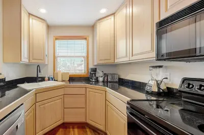 a kitchen with wooden cabinets and black counter tops at Cabin Sweet Cabin in Winter Park