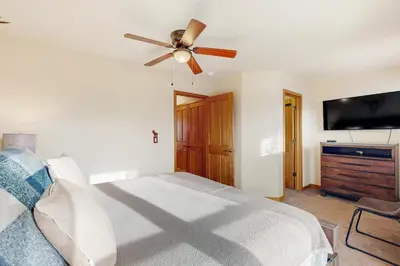 a bedroom with a bed and a ceiling fan at Cabin Sweet Cabin in Winter Park