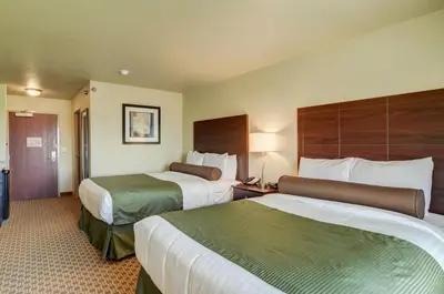 a hotel room with two beds and a room with two at Cobblestone Inn & Suites-Kersey in Kersey