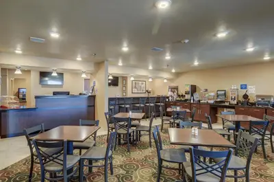 a restaurant with tables and chairs and a bar at Cobblestone Inn & Suites-Kersey in Kersey