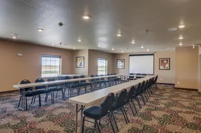 a conference room with tables and chairs and a whiteboard at Cobblestone Inn & Suites-Kersey in Kersey