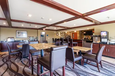 a restaurant with tables and chairs and a bar at Cobblestone Inn and Suites - Eaton in Eaton