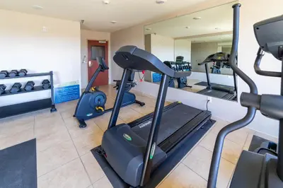 a gym with several treadmills and a mirror at Cobblestone Inn and Suites - Eaton in Eaton