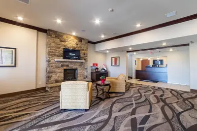 a living room with chairs and a fireplace at Cobblestone Inn and Suites - Eaton in Eaton