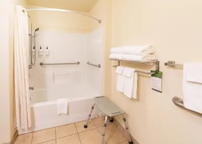 a bathroom with a shower and a toilet and towels at Cobblestone Inn and Suites - Eaton in Eaton