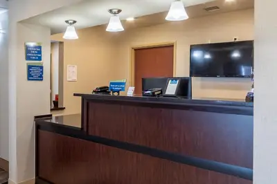 a lobby with a reception desk with a flat screen tv at Cobblestone Inn and Suites - Eaton in Eaton