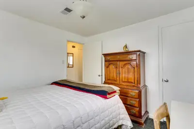 a bedroom with a bed and a wooden dresser at Dog-Friendly Denver Apartment with Shared Yard! in Denver