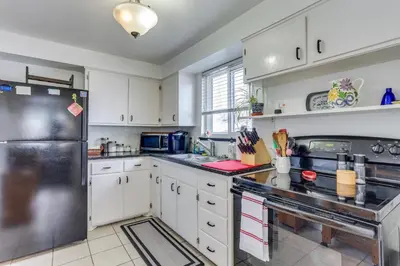 a kitchen with white cabinets and a stainless steel refrigerator at Dog-Friendly Denver Apartment with Shared Yard! in Denver