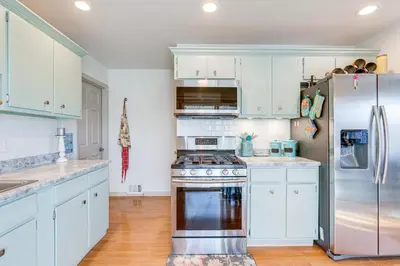 a kitchen with white cabinets and a stainless steel refrigerator at 4 Mi to Hwy Access for Mtn Fun Family Getaway! in Lakewood