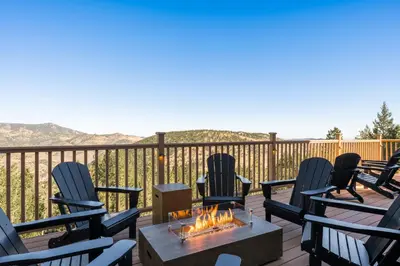 a group of chairs sitting around a fire pit on a deck at Stay in Evergreen - Denver Mountain Escape in Evergreen