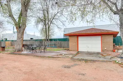 a house with a garage and a table in a yard at 5 Mi to Dtwn Denver Pet-Friendly Home with Patio in Denver