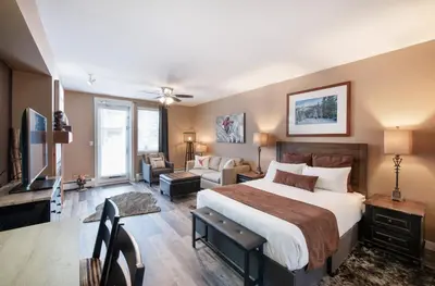 a bedroom with a large bed and a living room at Premium Unit 4371- Fraser Crossing Founders Pointe condo in Winter Park