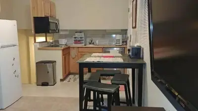 a kitchen with a table and some stools in it at Broomfield Home in Broomfield