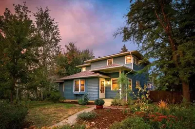 a blue house in a yard with trees at Beautiful Historic House in Central Longmont in Longmont