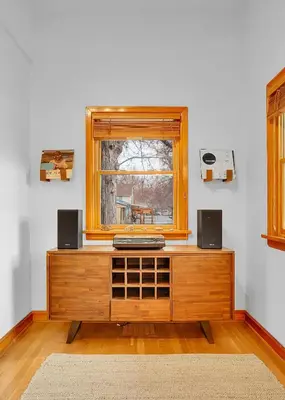 a room with a wooden cabinet with speakers and a window at Beautiful Historic House in Central Longmont in Longmont