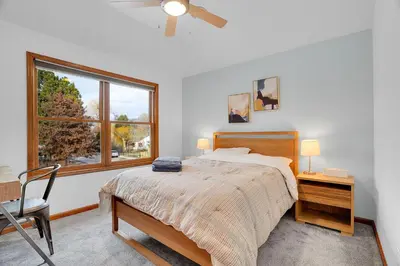 a bedroom with a bed and a chair and a window at Beautiful Historic House in Central Longmont in Longmont