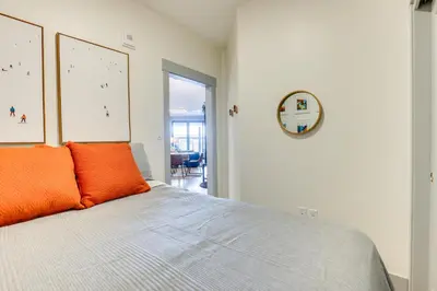 a bedroom with a bed with orange pillows on it at Downtown Winter Park Condo 3 Mi to Slopes! in Winter Park