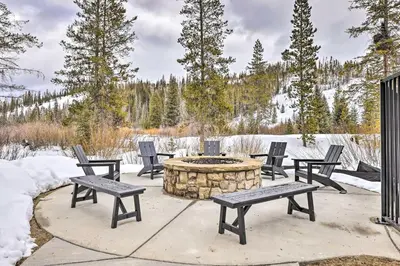 a group of chairs around a fire pit in the snow at Downtown Winter Park Condo 3 Mi to Slopes! in Winter Park