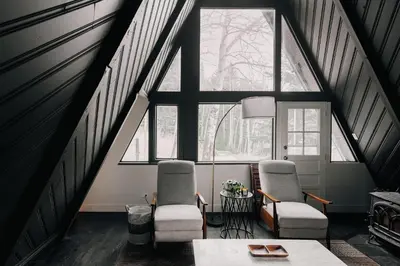 a room with two chairs and a table in front of a window at Modern A-Frame - Mountain Views - Evergreen in Evergreen