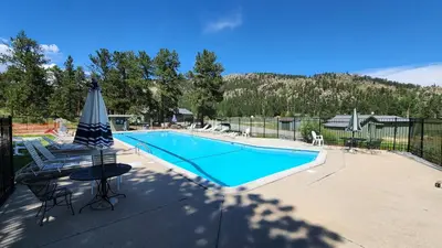 a swimming pool with a table and an umbrella at Cozy Mountain Home with Great Views, Deck & WiFi in Lyons