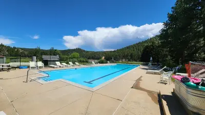 a large swimming pool with chairs and a boat at Cozy Mountain Home with Great Views, Deck & WiFi in Lyons