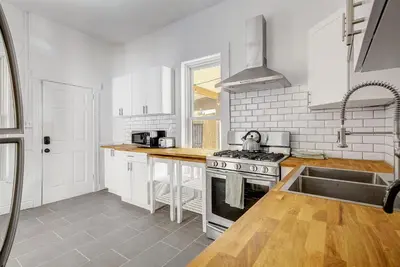 a white kitchen with a stove and a sink at Stiles Historical Estate - 26th St in Denver